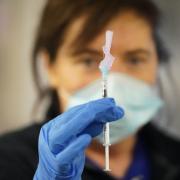 Photo of an NHS nurse holding the coronavirus vaccine. Image by PA.