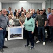 Jackie Godwin receives a signed picture from her brother Terry Smith, surrounded by colleagues past and present