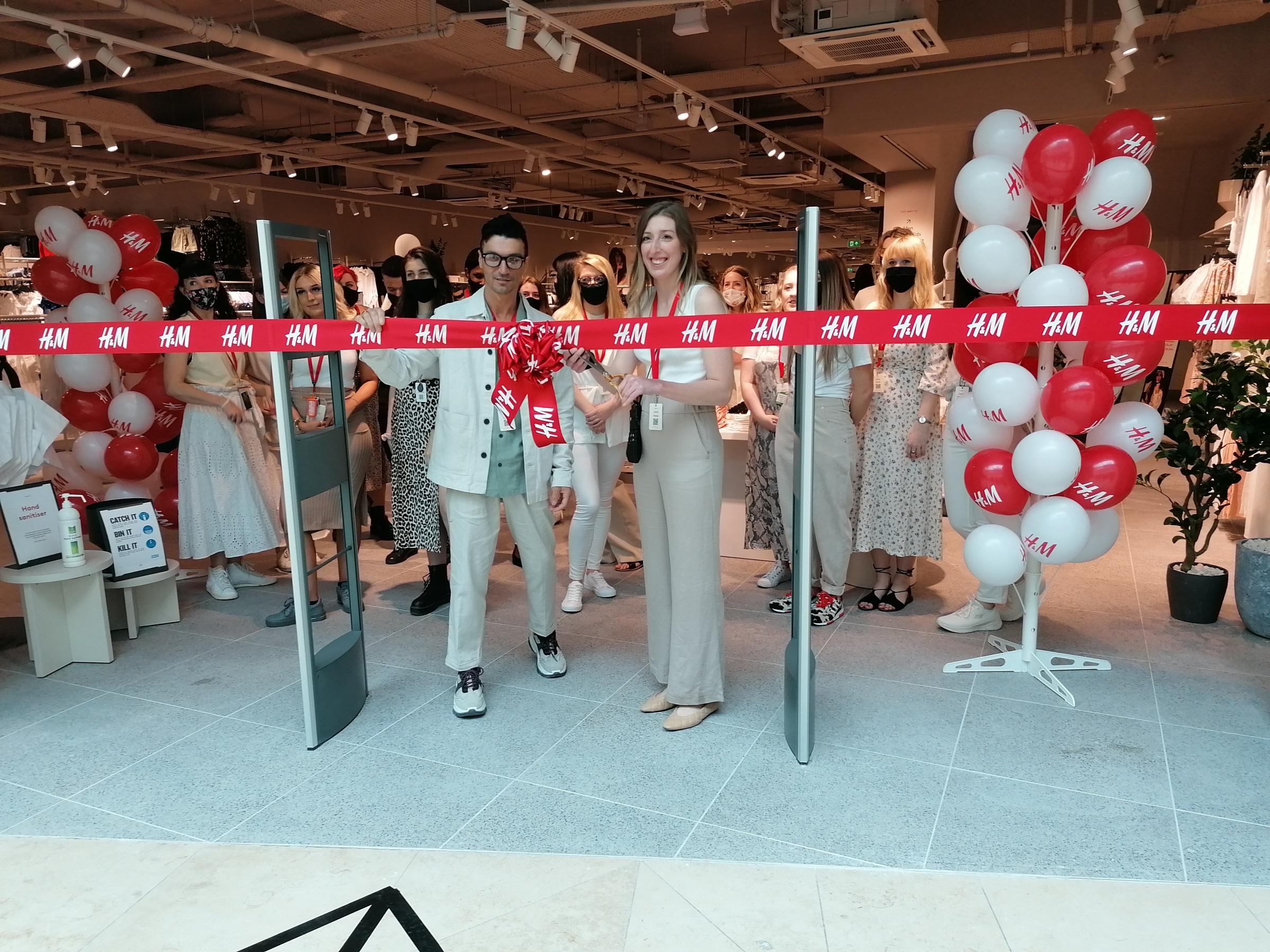 Area manager Dimitrios Makris and Emily Jazz cut the ribbon on the new store.