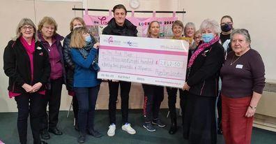 Ben Boon, joint director of PomPom London Ltd, hands over the donation cheque to The Pink Place volunteers and staff