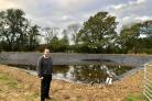 Farm and Farm Shop owner Graham Collett in front of the water reservoir