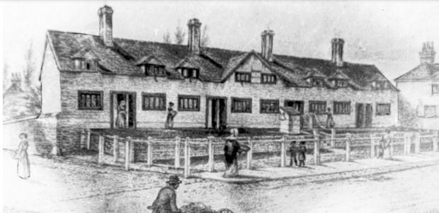 Basingstoke Gazette: Deane’s Almshouses in the mid-19th century, showing the pig market stalls in front of the building 