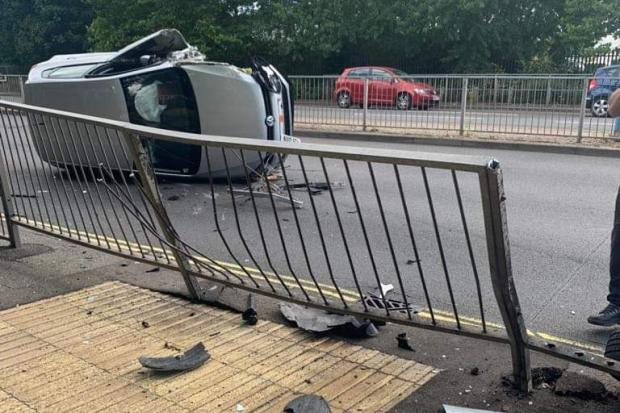 Car flips onto side after crashing into railings