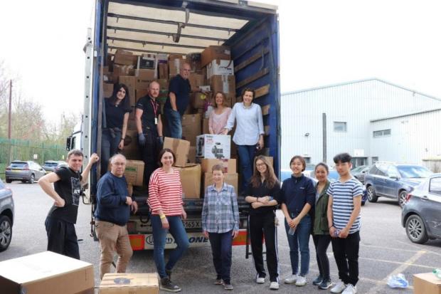 Members of the Absolutely Offices team alongside alongside a lorry of donations.