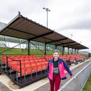 Cllr Jenny Vaux stands in front of the new spectator stand at Down Grange Sports Complex.